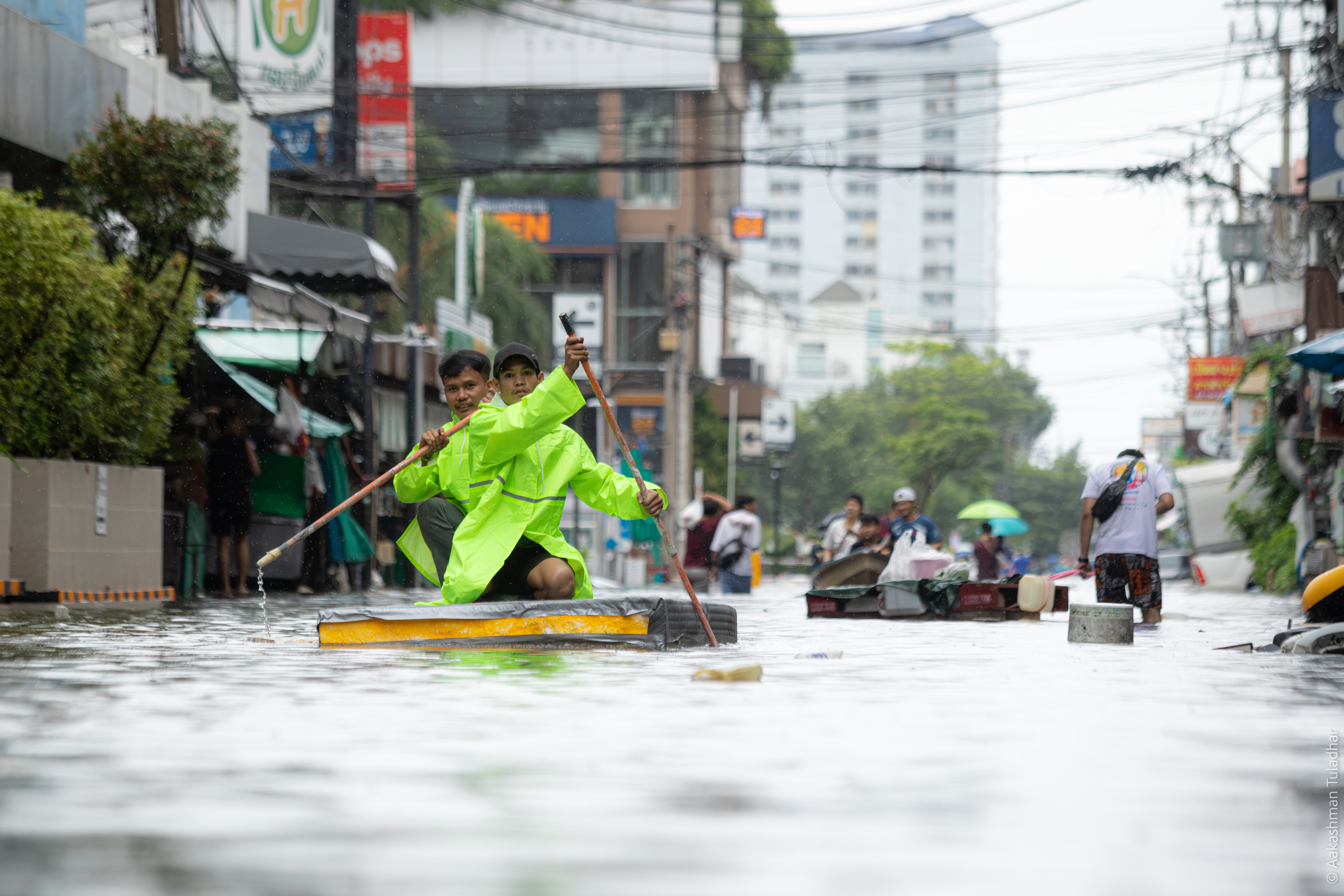 Woman carrying supplies through chest-deep floodwater