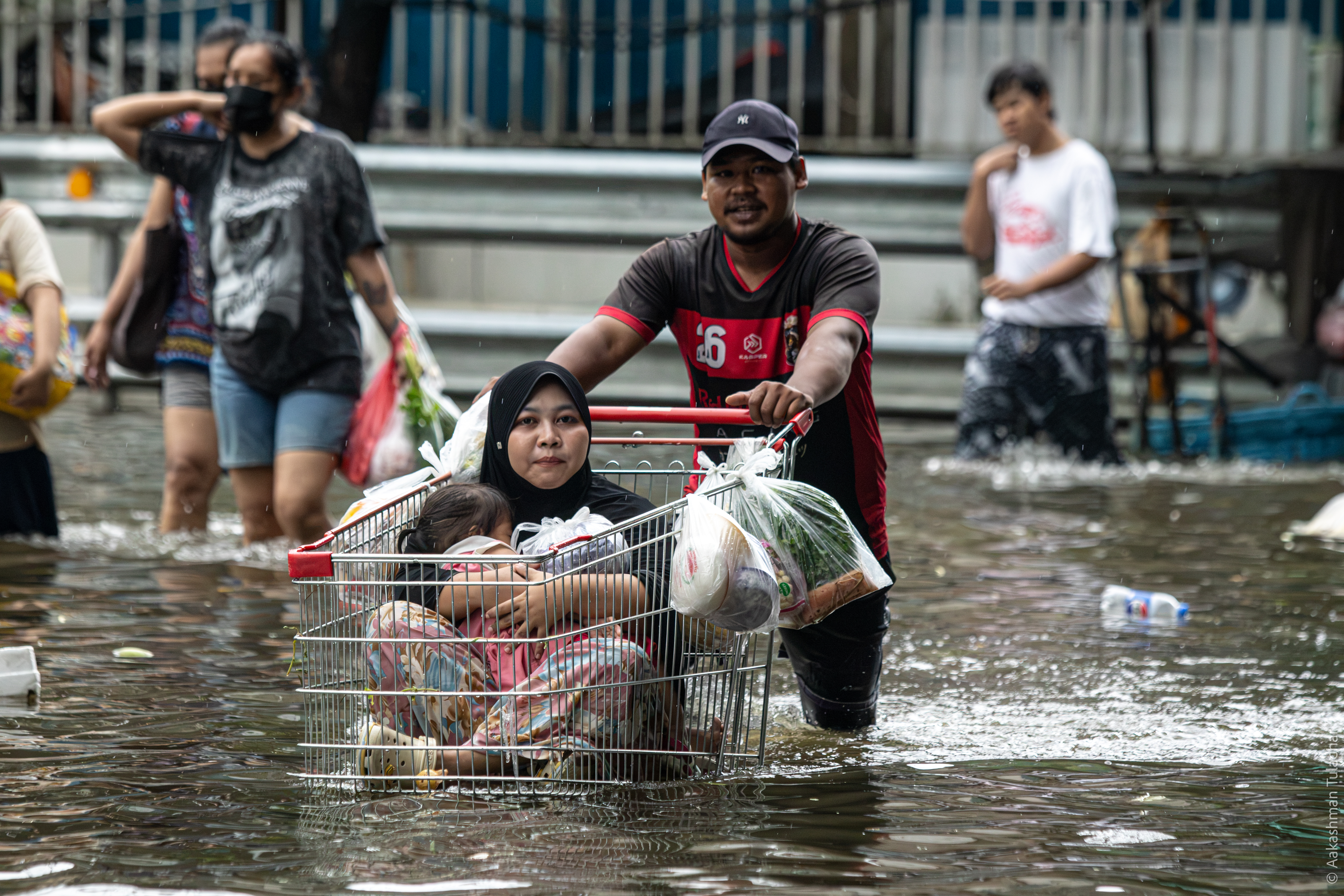 Residents crossing floodwater on an inflatable mattress, Bangkok